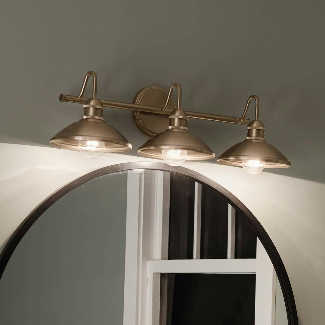 Night time bathroom with Clyde 3 Light Vanity Light Champagne Bronze