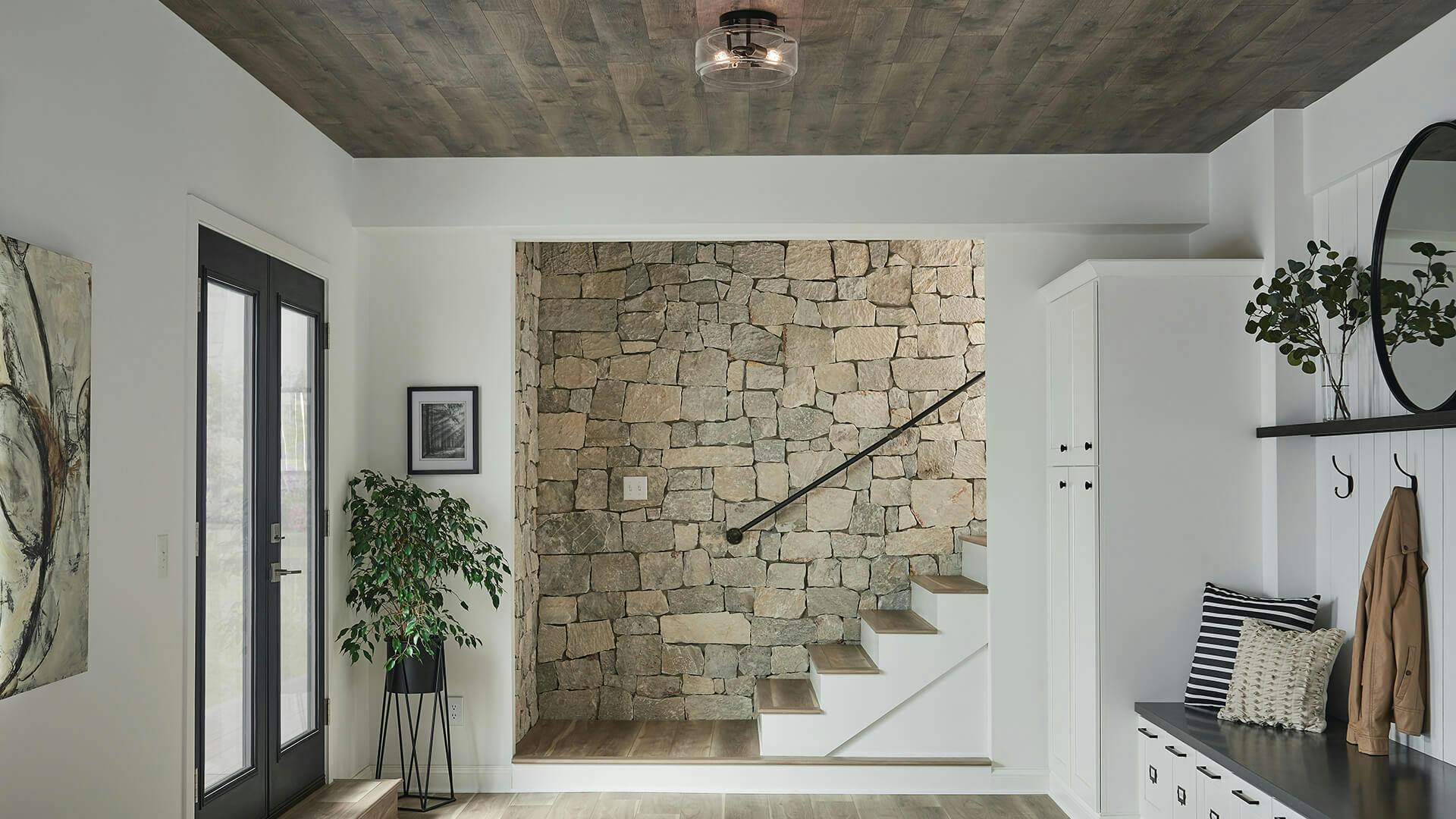 Mudroom with a stone-walled staircase in the background and a lit Alamosa mounted on a wood ceiling