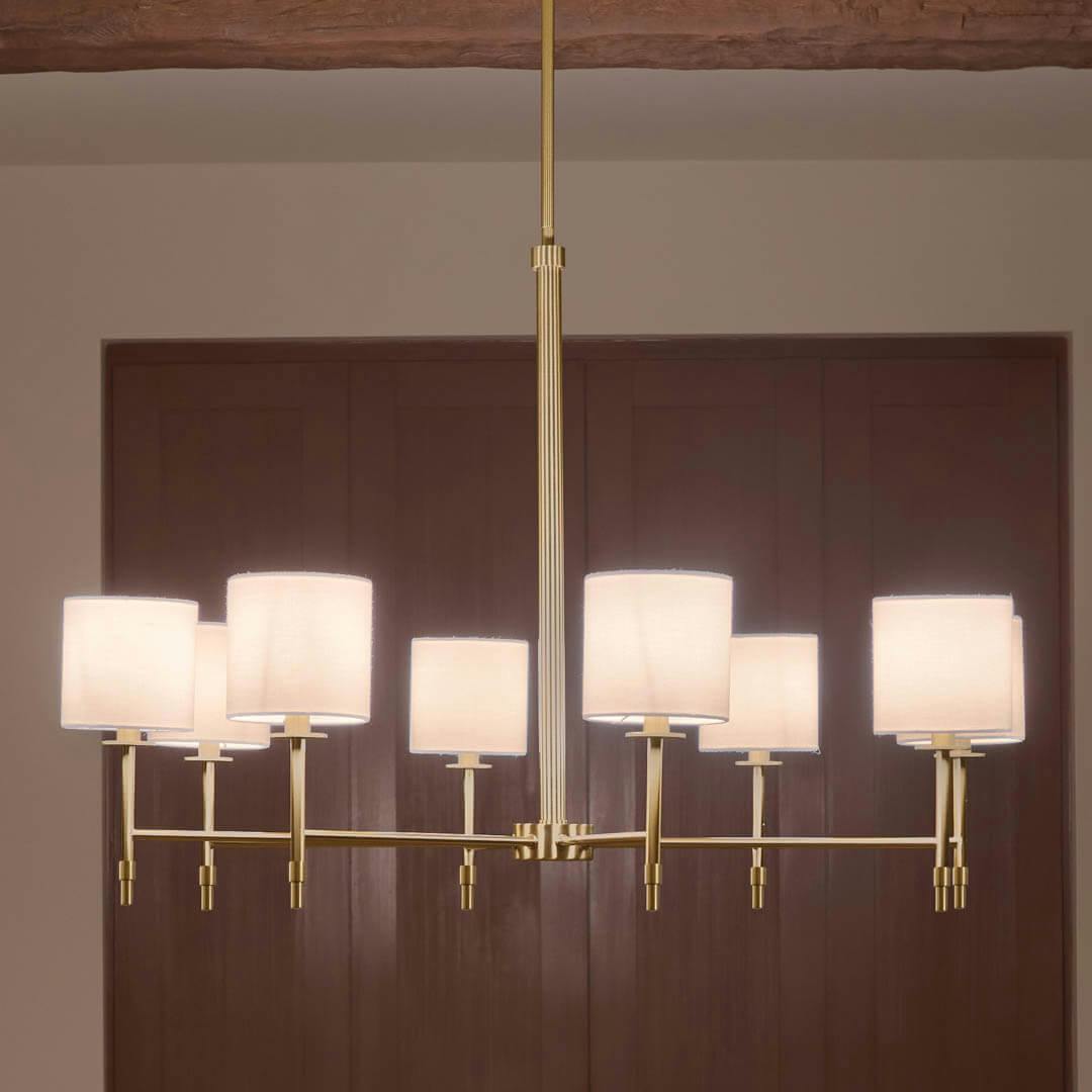 Night time dining room with Ali 38.5" 8 Light Chandelier Brushed Natural Brass