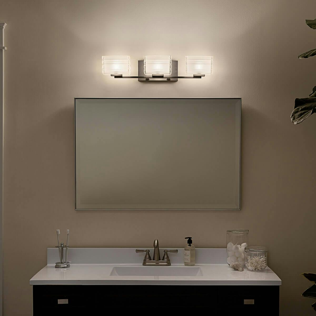 Night time Bathroom featuring Bazely vanity light 45479NI