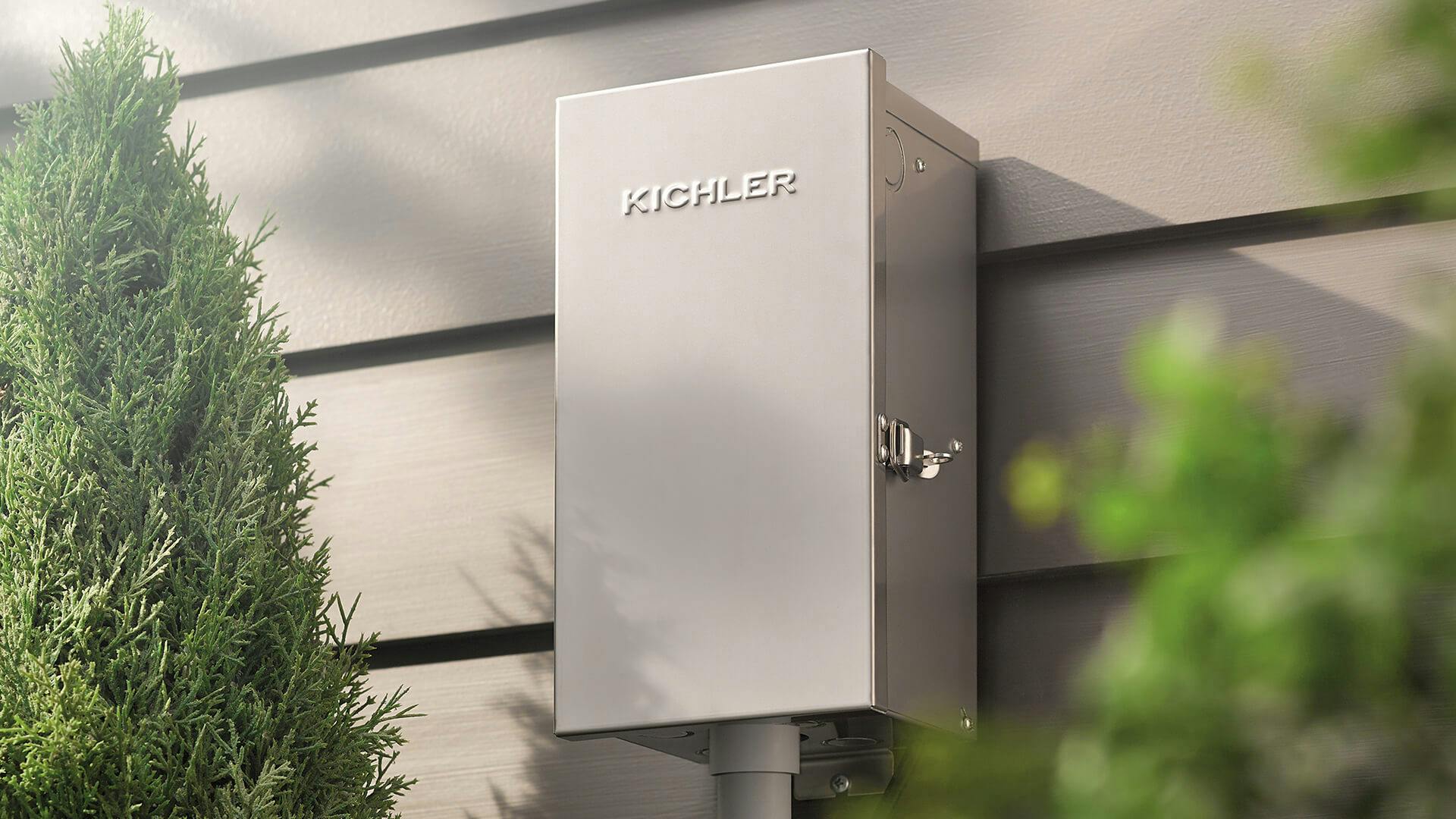 Close up of a grey Kichler transformer box on an exterior wall.