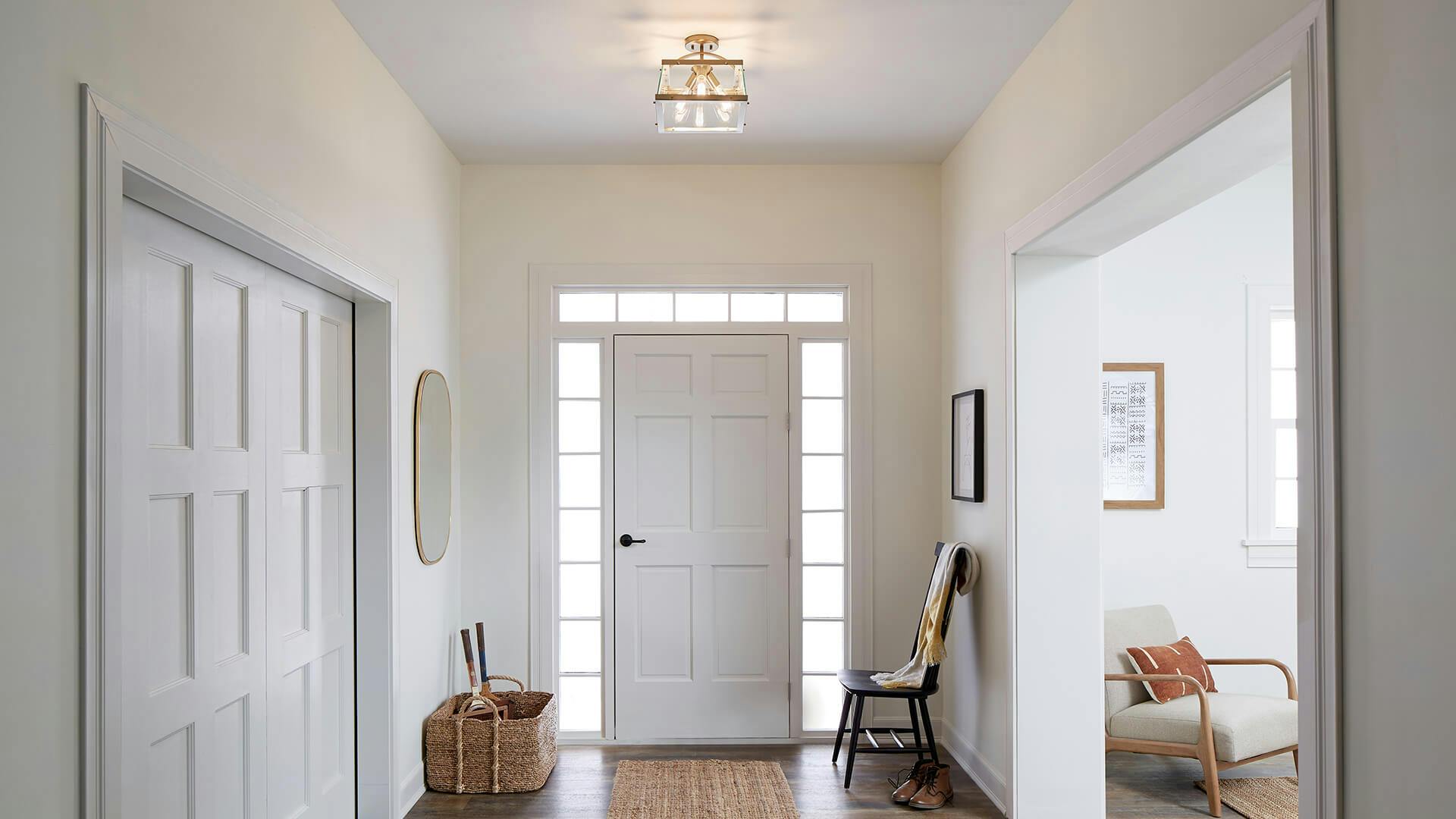 Entryway painted white with a Darton chandelier hanging above the front door